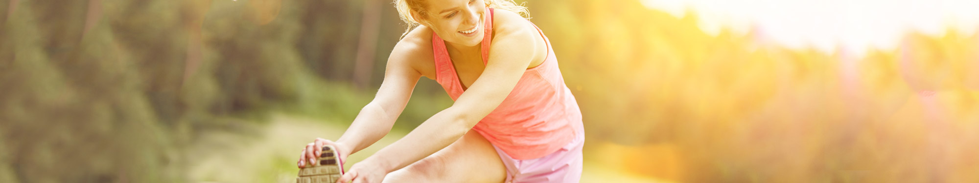 girl getting ready for exercise, holding her foot and stretching her leg