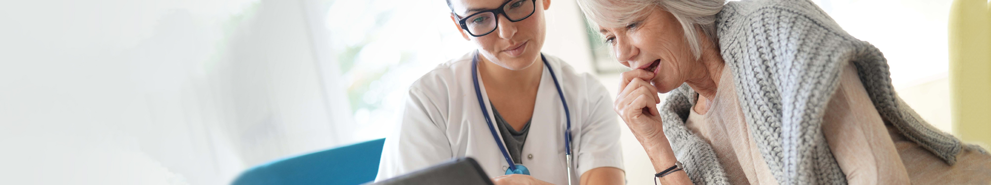 older woman looking over a tablet with provider