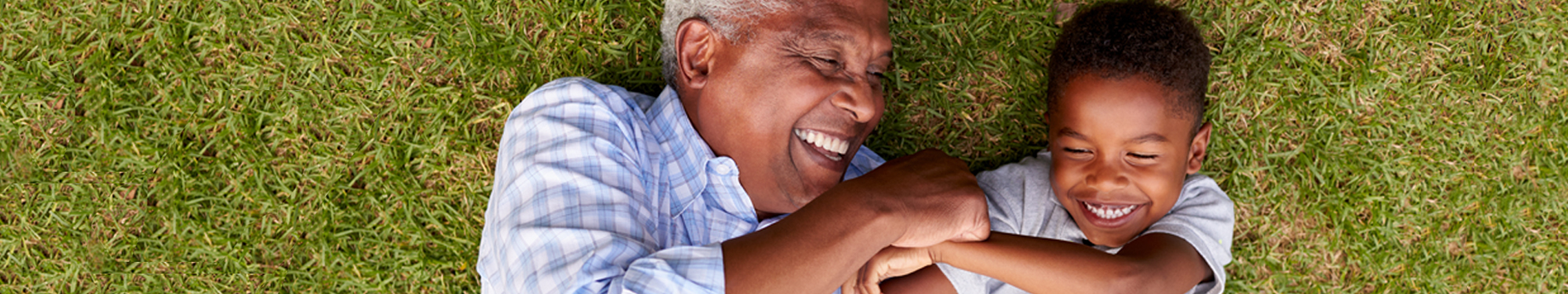 Man and grandson playing in grass