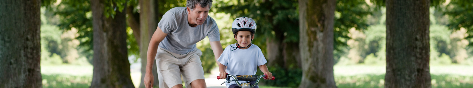 Man helping kid ride a bike