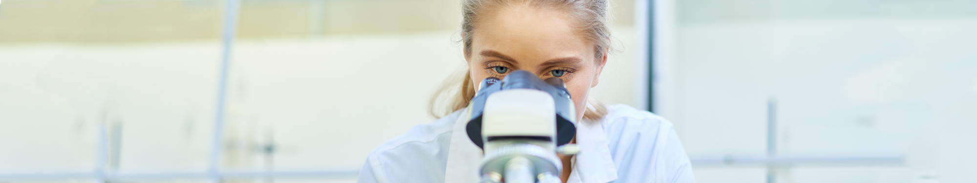 Healthcare worker looking into a microscope