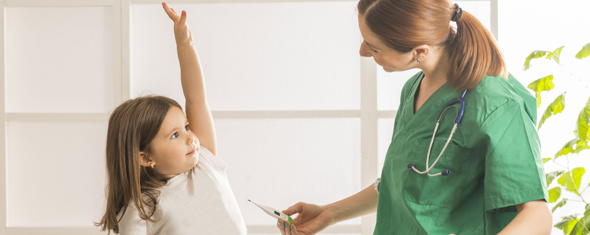 young girl raising her hand and talking to her provider